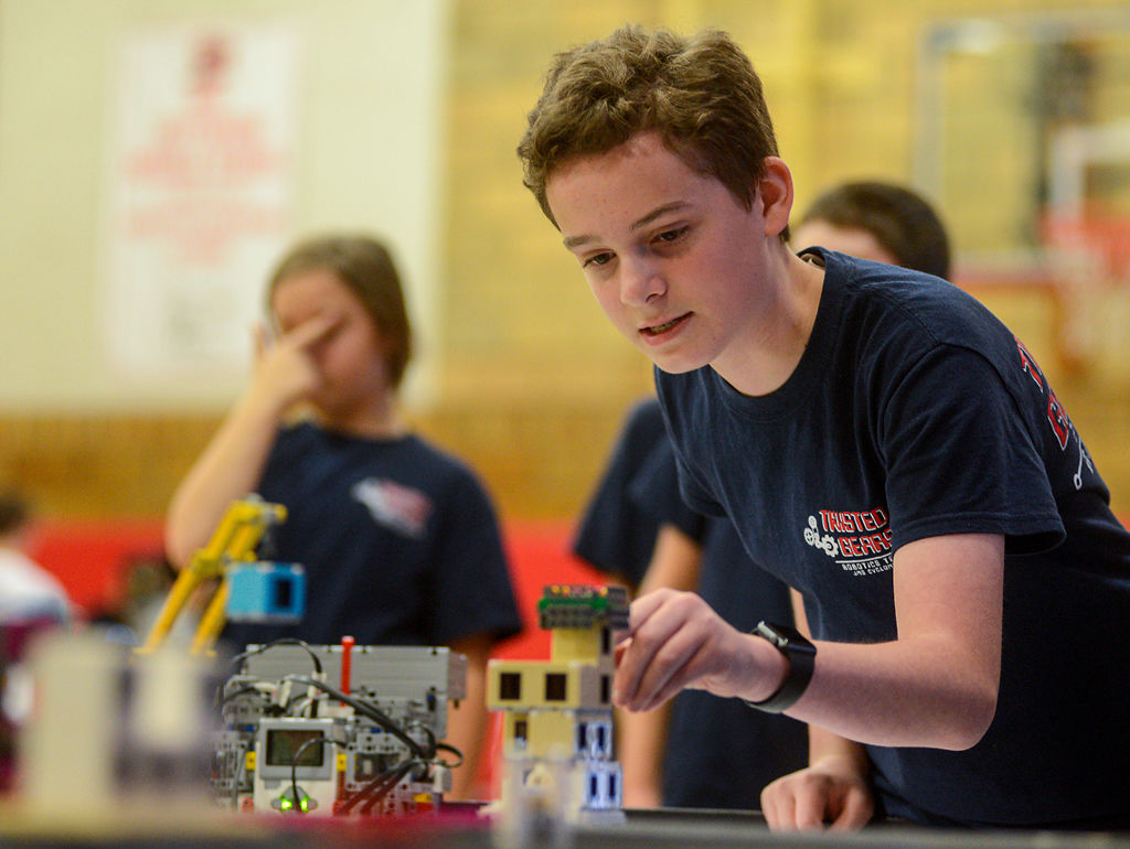 Gabe Palmer, 12, prepares his team's LEGO robot before the start of a competition